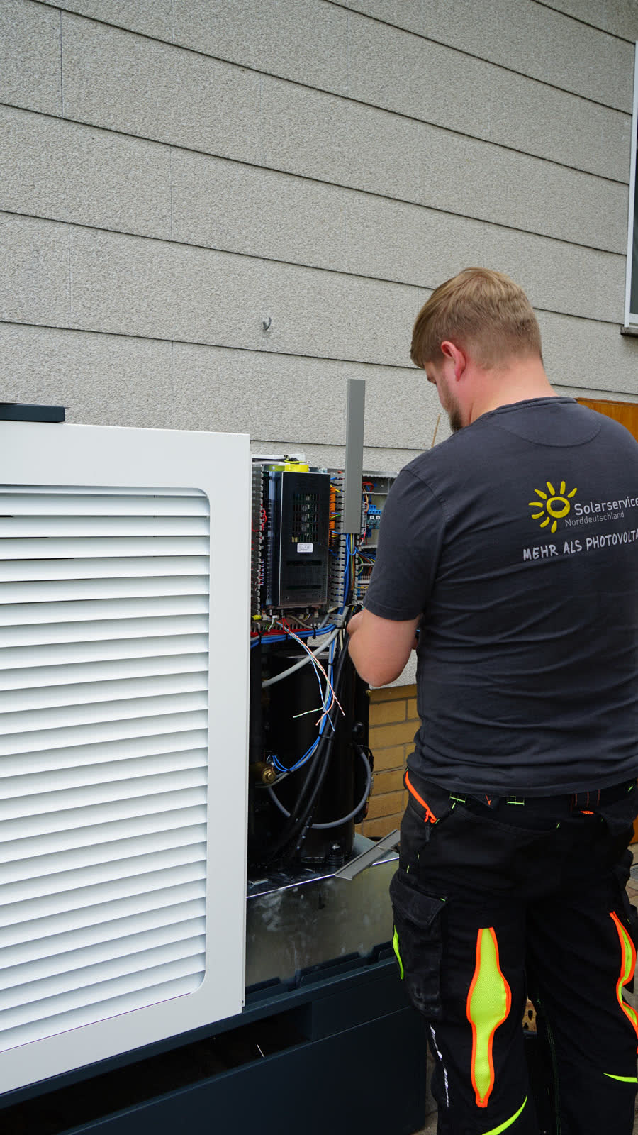 Monteur von Solarservice Norddeutschland beim elektrischen Anschluss einer Wärmepumpe